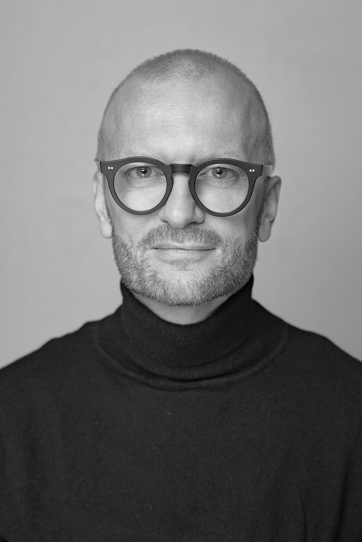 My portrait: I look straight at the camera, wearing dark glasses and a black polo-neck jumper.